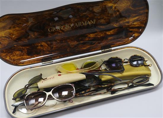 A collection of twelve vintage and designer glasses in an Armani shop display case